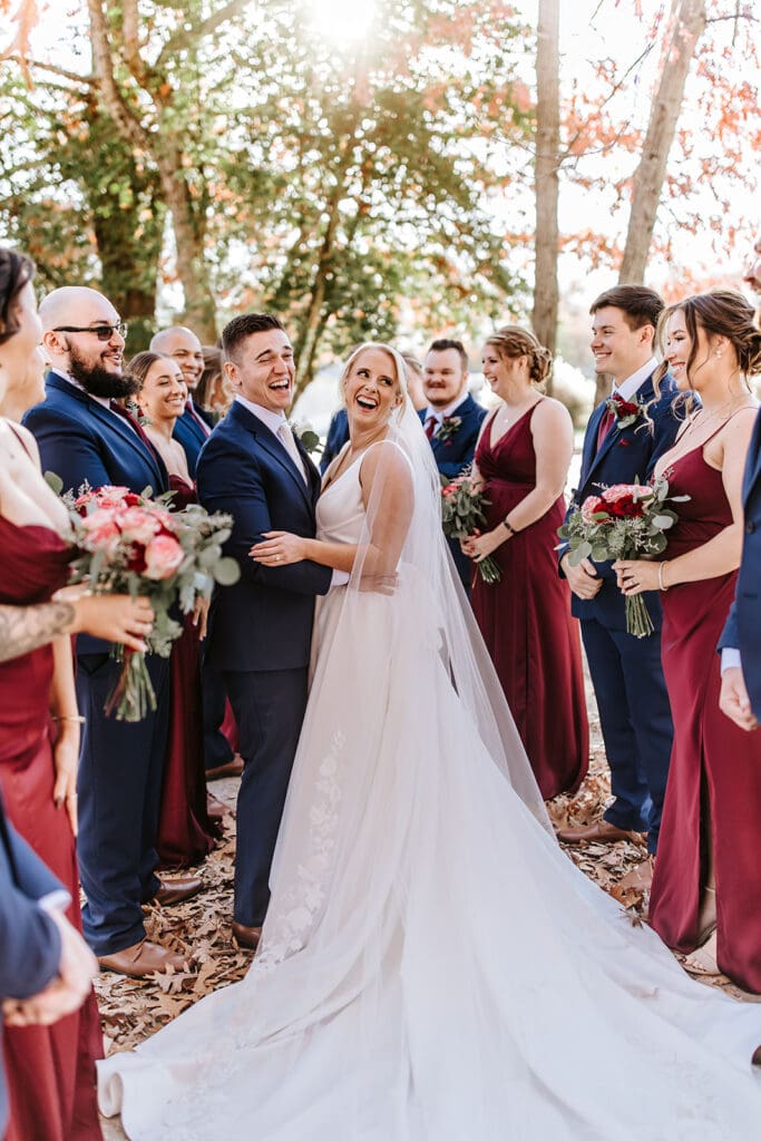 Bridal party celebrates the newlyweds in a golden hour moment under fall foliage at The Grove at Centerton in South Jersey.
