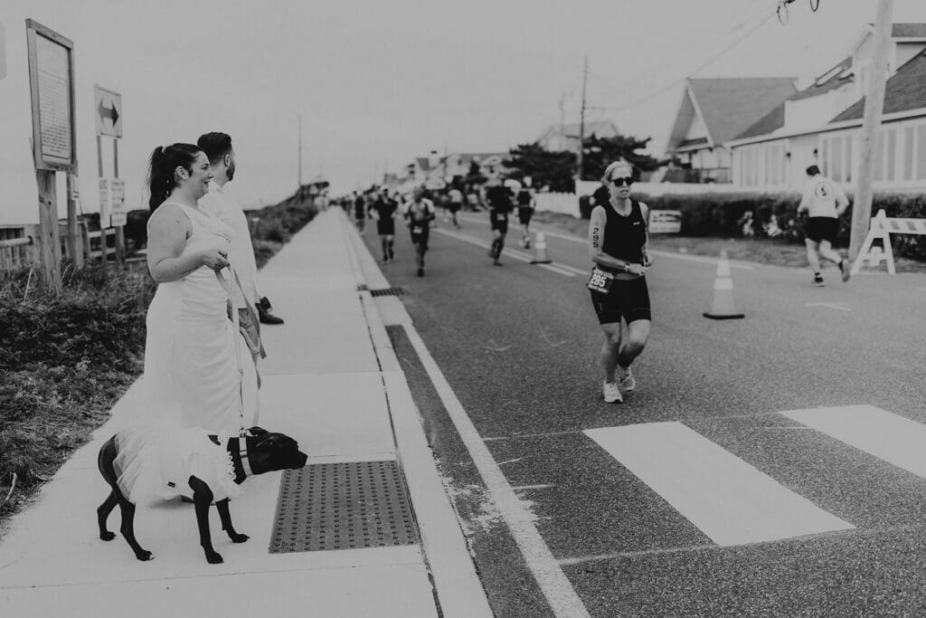 Bride and groom-to-be wait to cross the street during Escape the Cape Triathlon in Cape May, their dog in a white dress beside them