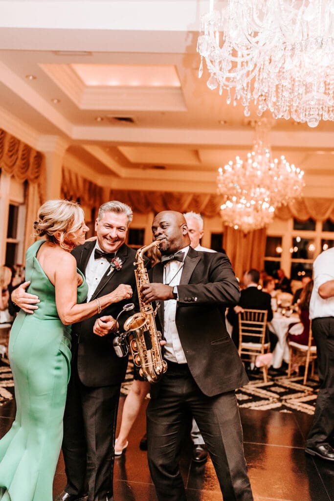 Live trumpet player from The James White Band joins wedding guests on the dance floor at a Philadelphia reception.