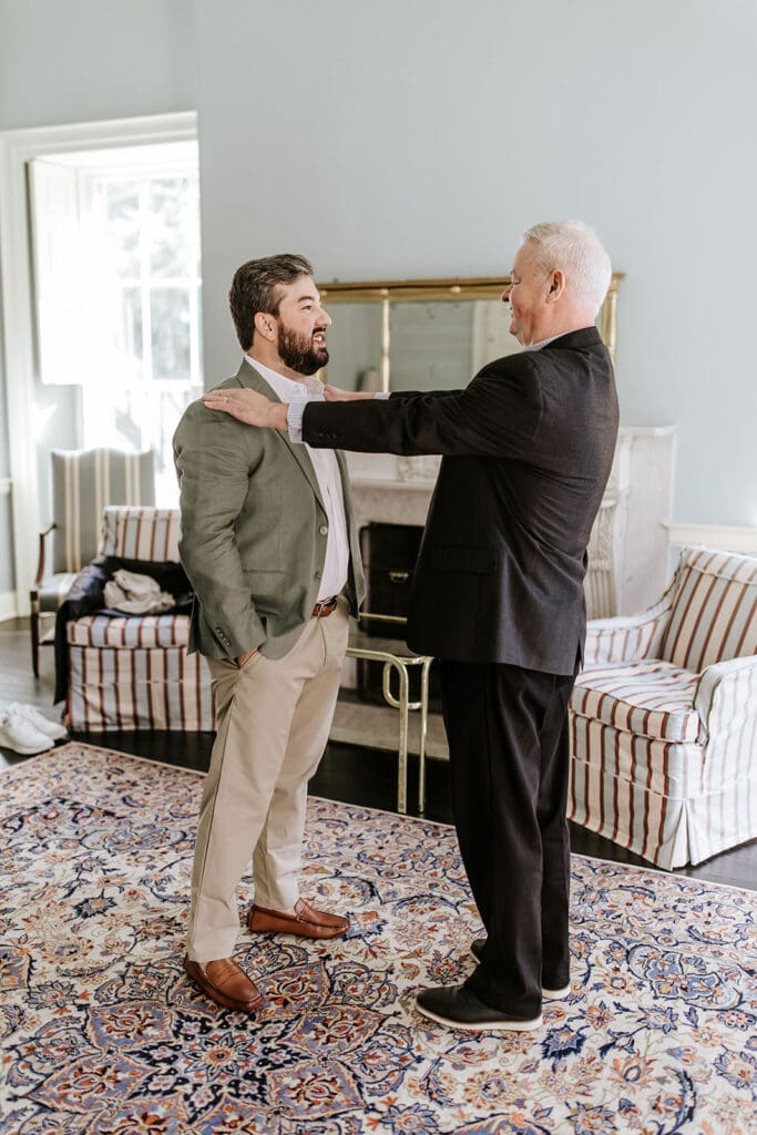 Groom sharing a candid moment with his father before the ceremony inside Highlands Mansion, Philadelphia wedding photographer capturing authentic family moments.