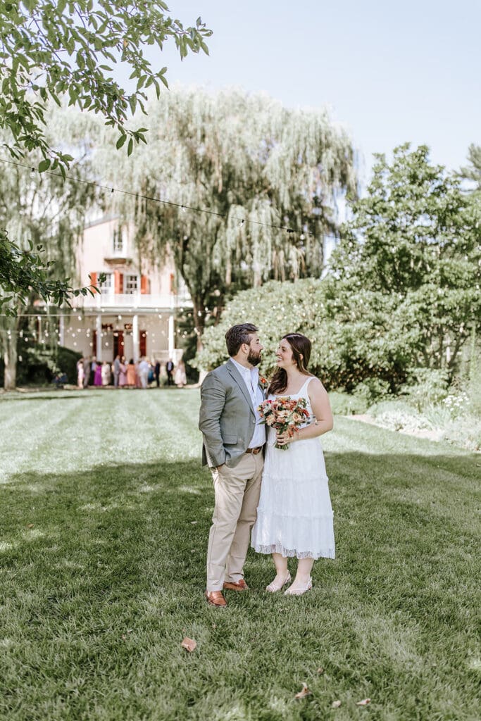 Bride and groom celebrating with 24 family members during an intimate Highlands Mansion wedding in Philadelphia, group photo outside the historic venue.