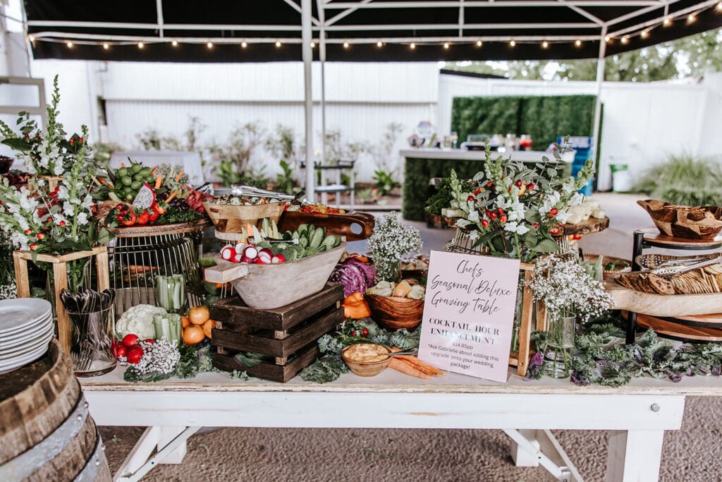 Cocktail hour grazing table at Ramblewood Country Club featuring fresh fruits, vegetables, breads, and styled floral décor.