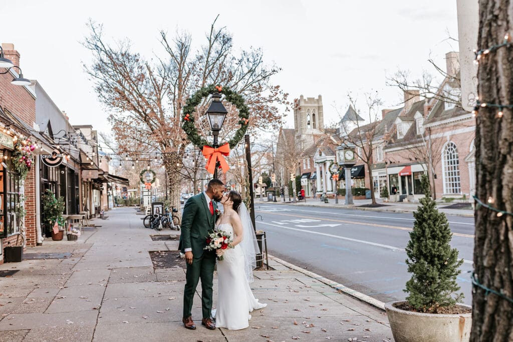 Bride and groom sharing a quiet moment during winter wedding portraits in downtown Haddonfield, NJ with Christmas wreaths and seasonal décor.