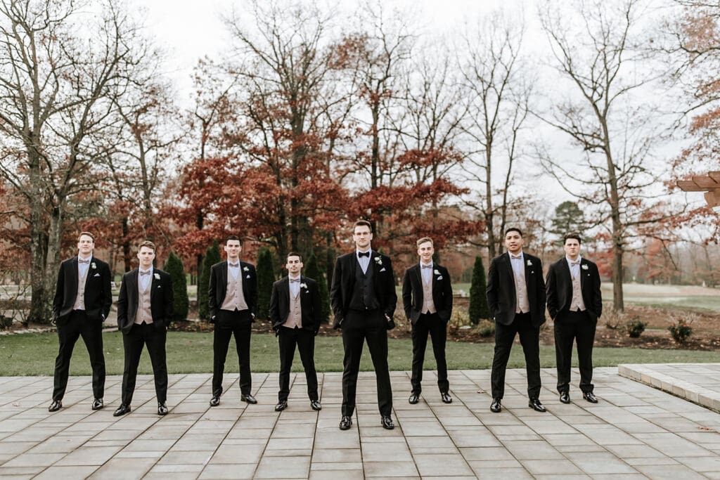 Groomsmen lined up for a formal portrait on the patio at Running Deer Golf Club in South Jersey.