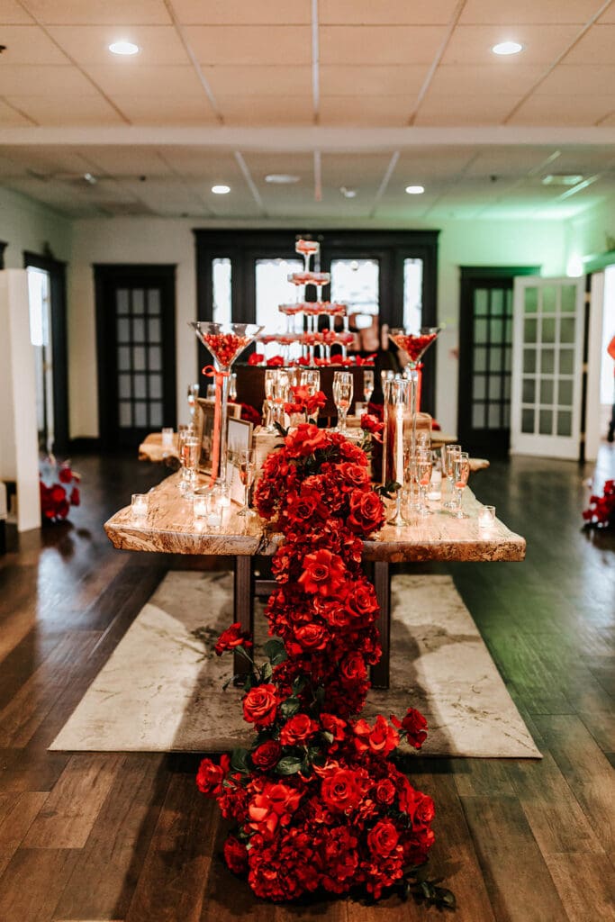 Romantic sweetheart table design with cascading red florals and candlelight at the Cherry On Top Wedding Showcase inside Running Deer Golf Club’s ballroom in South Jersey.