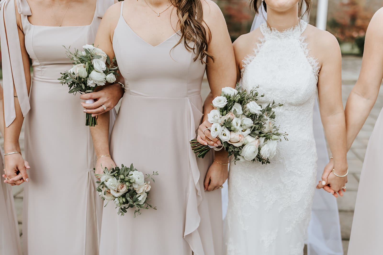 Bride standing with her bridal party in neutral dresses, symbolizing wedding party dynamics and support during the wedding planning process.