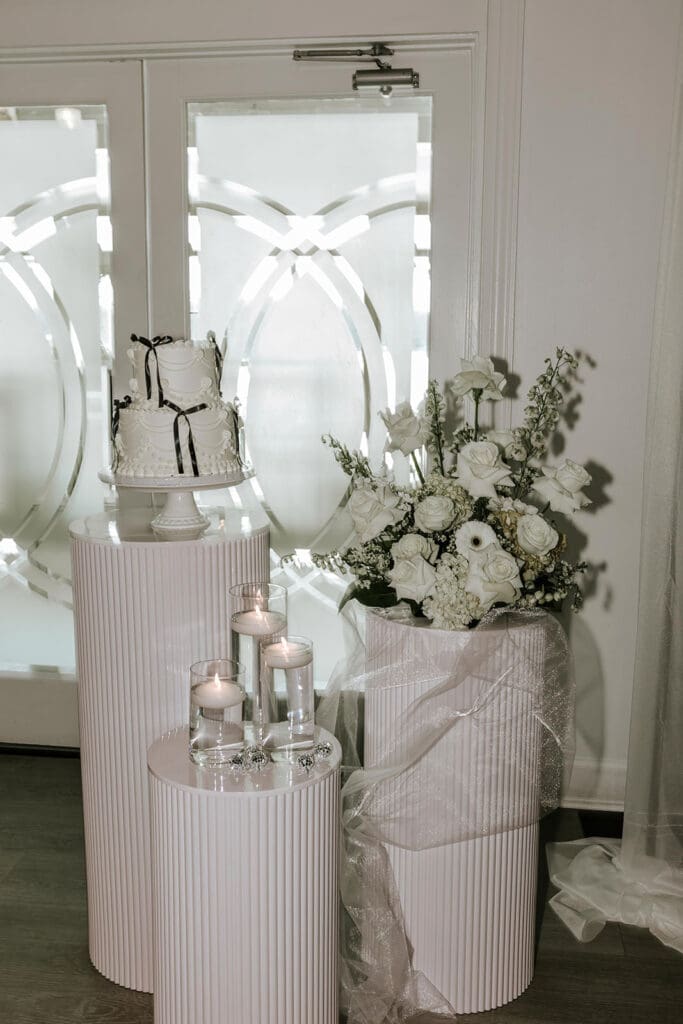 Wedding cake and floral display inside Valleybrook Country Club in Blackwood, NJ featuring soft neutral tones, candlelight, and elegant reception details.