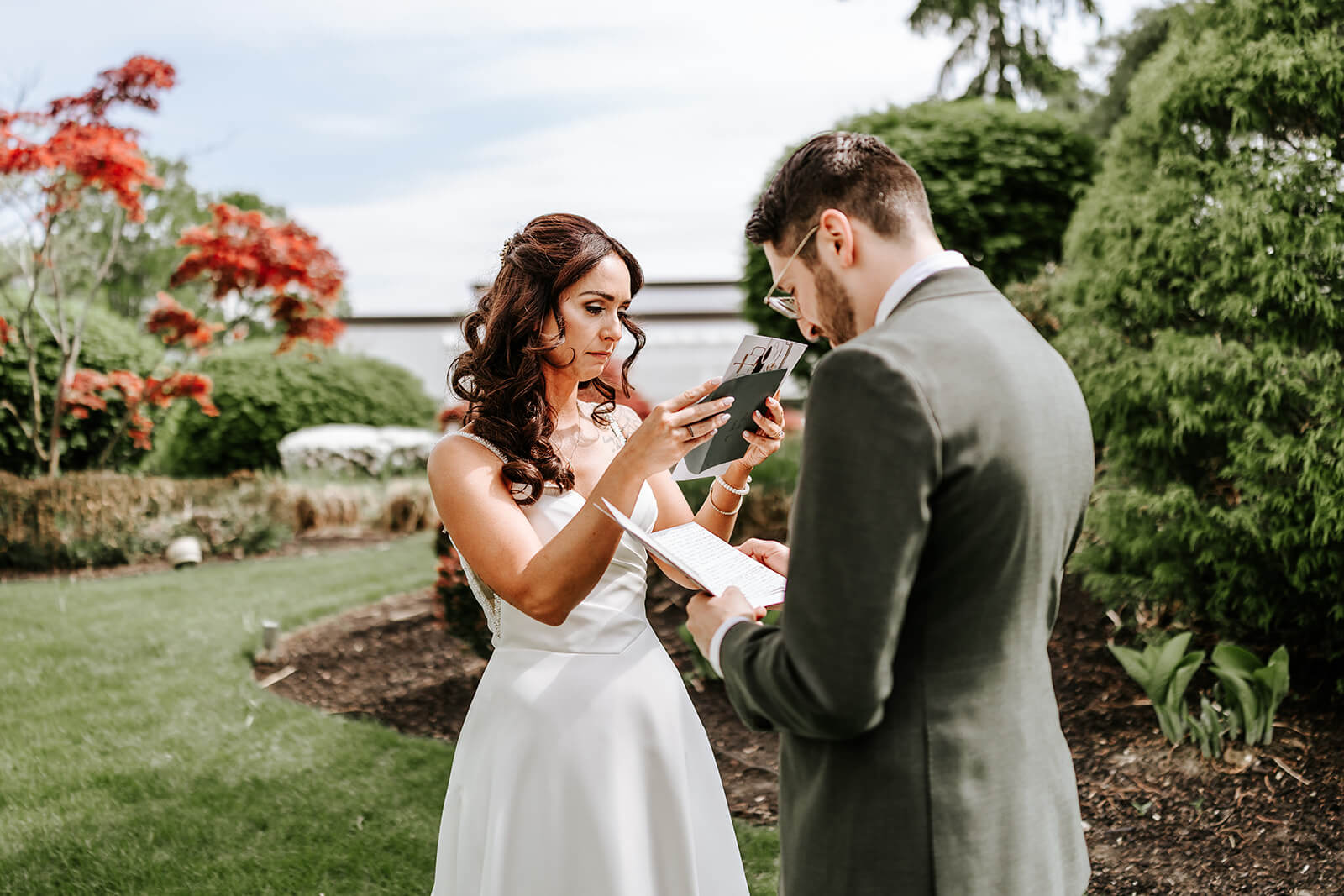 Bride reading handwritten wedding vows during intimate first look