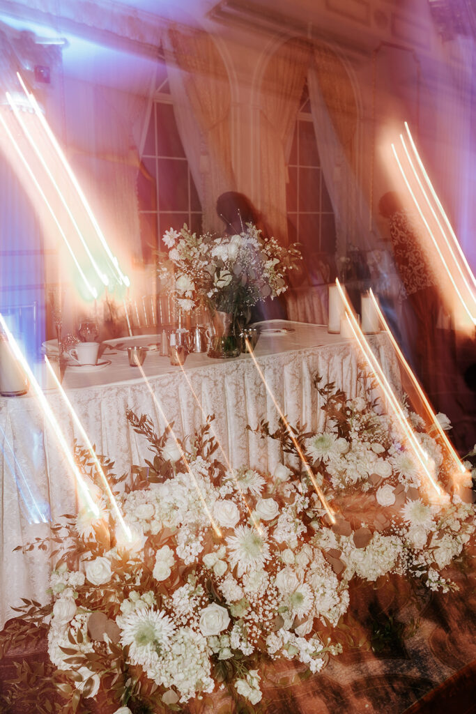 Elegant wedding reception decor with floral centerpieces and chandeliers at The Merion in Cinnaminson NJ