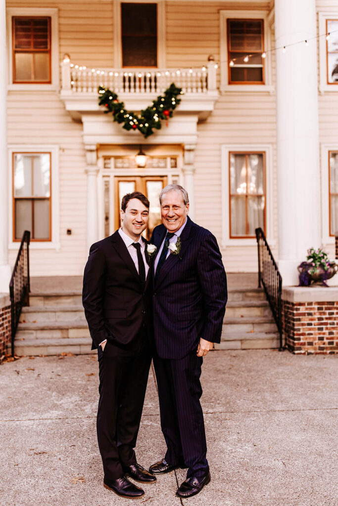 Groom and his father smiling together outside the historic Collingswood Grand Ballroom