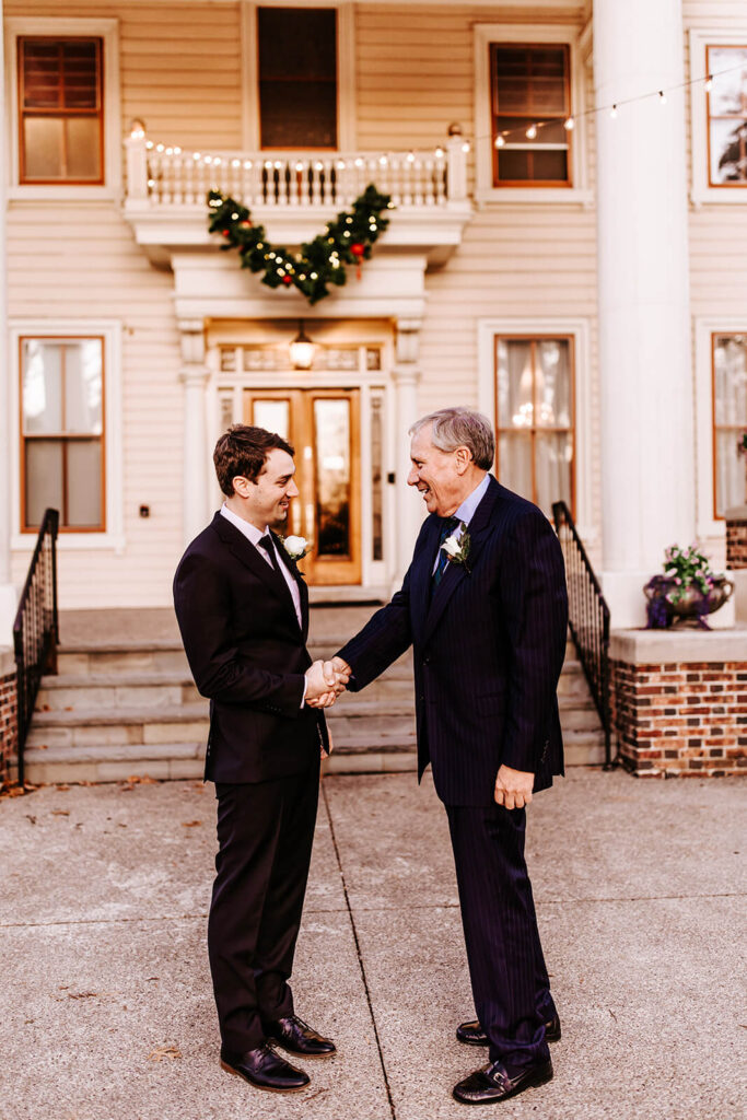 Groom sharing a handshake with his father outside Collingswood Grand Ballroom