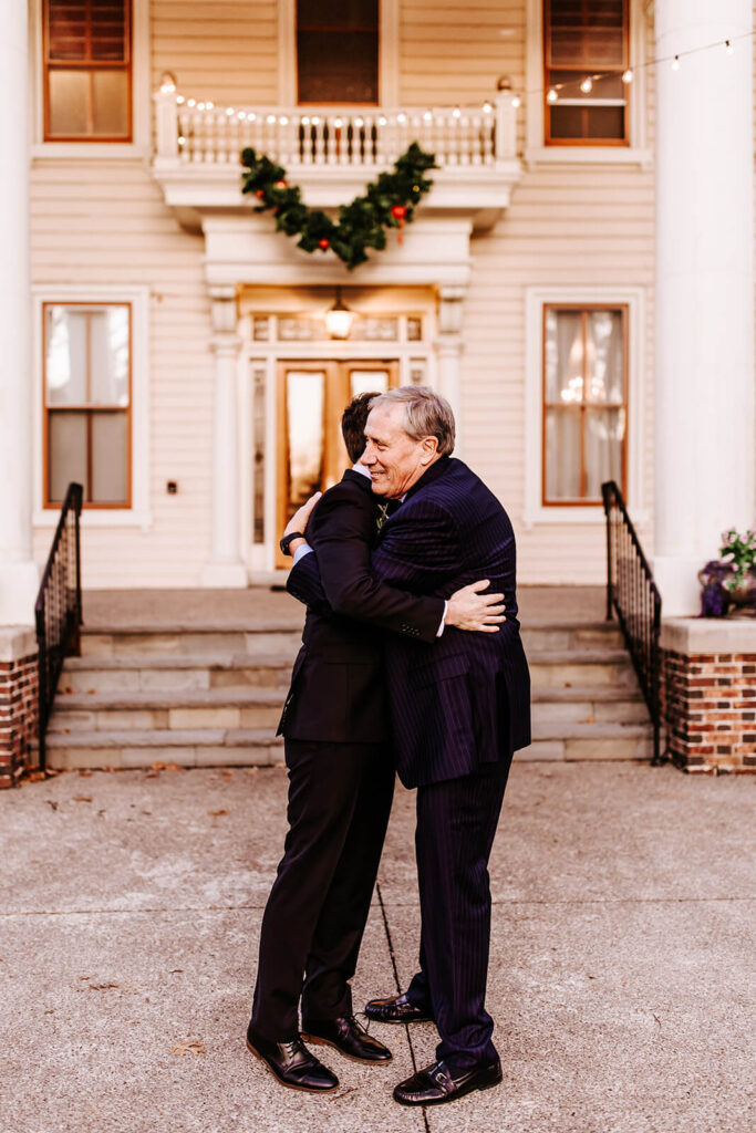 Groom hugging his father outside the Collingswood Grand Ballroom before the wedding