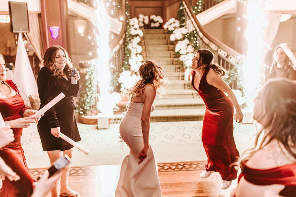 Bride celebrating with bridesmaids on the grand staircase at Collingswood Grand Ballroom